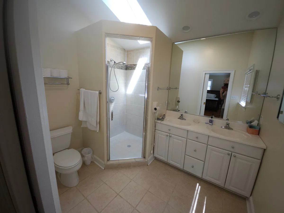 A modern bathroom featuring a spacious shower area, double sink vanity, and large mirror. Clean lines and soft lighting evoke a sense of relaxation and personal care.